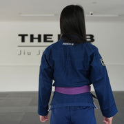 Hooks BJJ Gi Prolight II Navy, back view worn, showing collar logo, sleeve patch, and purple belt tied at waist