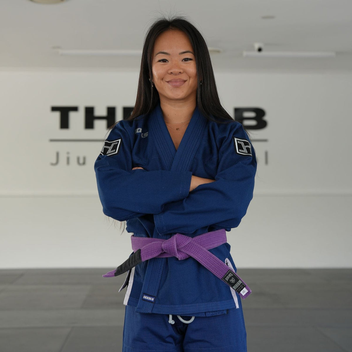 Hooks BJJ Gi Prolight II Navy, worn by a person with arms crossed, paired with a purple belt, front view