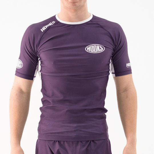 Hooks Fusion Short Sleeve Rash Guard in Plum, front view worn, purple with white side panels and chest logo