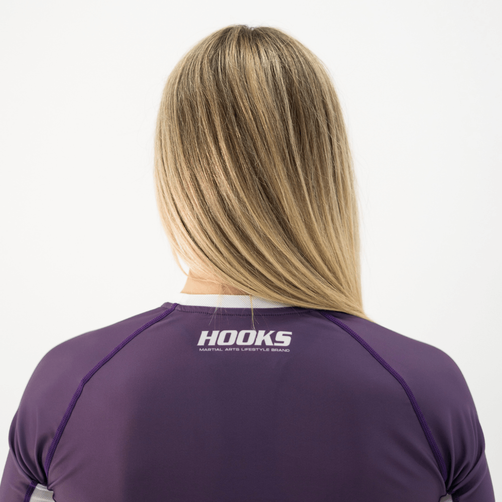 Hooks Women's Fusion Short Sleeve Rash Guard in Plum, back view worn, showing Hooks logo printed below the collar.