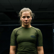 Hooks short sleeve rashguard in olive with black panels and chest logo, worn front view