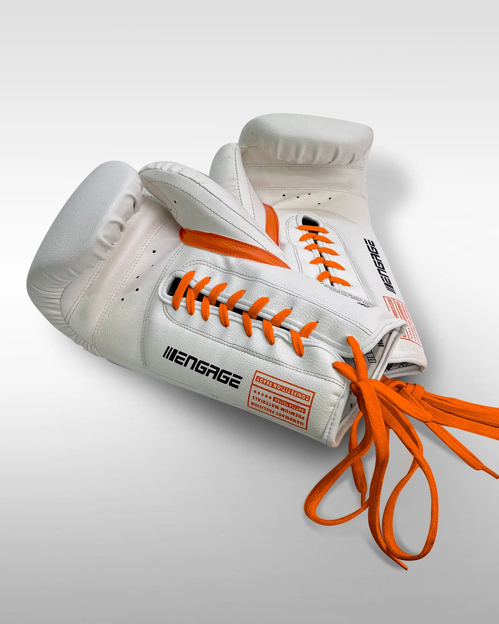 White boxing gloves with orange laces on a light gray background