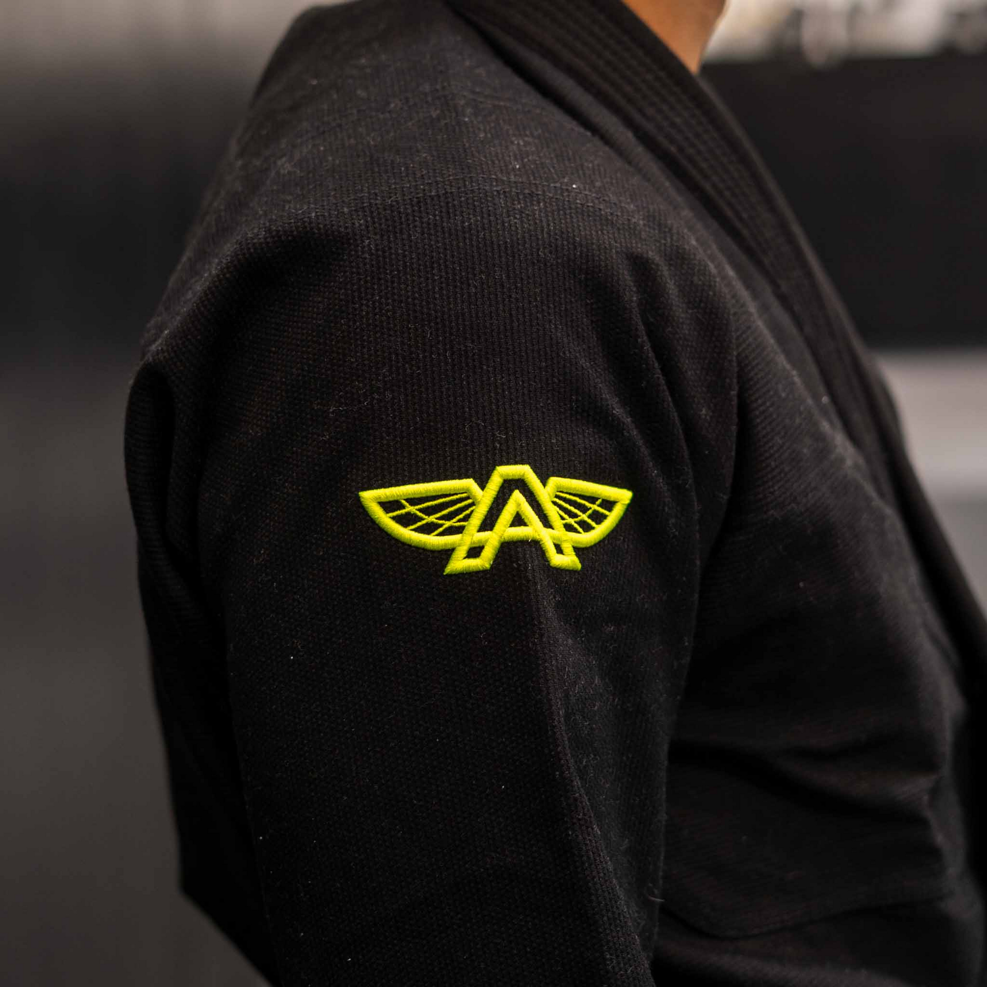Side view of The Atlas Brand ICON Black rashguard showing embroidered detail.